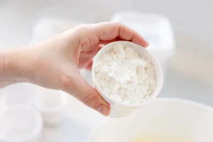 Segurando um pote de soro do leite em pó